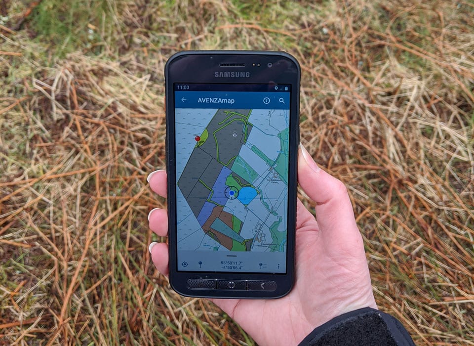 a forester holding a mobile device to view a map