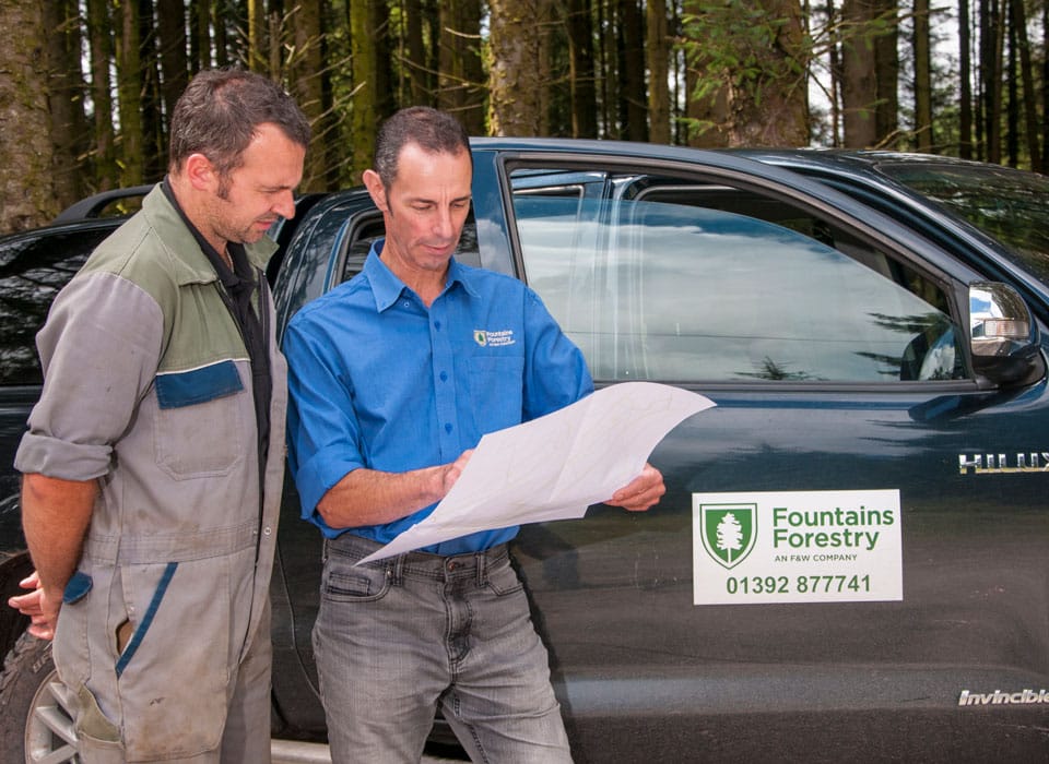 two foresters collaborating and looking at a map on the job